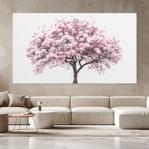 Può includere: Una stampa su tela bianca con un albero di magnolia rosa in piena fioritura su uno sfondo bianco. La stampa è esposta su una parete in un ambiente di soggiorno moderno.