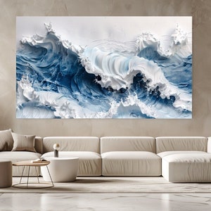May include: A large abstract painting depicting white and blue waves crashing against each other. The painting is hung on a wall in a living room setting.