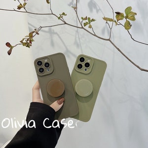 May include: Two olive green phone cases with a pop socket on each. The pop sockets are brown and green. The text "Olivia Case" is visible in the bottom left corner of the image.