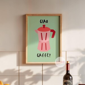 May include: A framed print with a green background and a pink and red illustration of a coffee pot. The text "Ciao Caffe?" is written in black on the print.