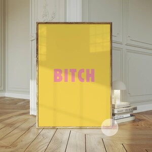 May include: A yellow poster with the word "BITCH" in pink letters.