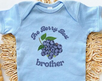 May include: Light blue baby onesie with a blueberry graphic and the text "The Berry Best Brother" in a retro font.