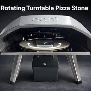 Könnte beinhalten: Ein silberner, rotierender Pizzaofen mit schwarzem Sockel und Beinen. Der Text "Rotating Turntable Pizza Stone" steht oben. Der Pizzastein im Ofen ist kreisförmig und dreht sich. Für das Backen von Pizzen konzipiert.
