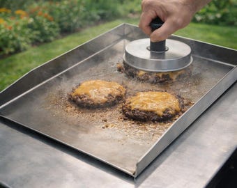 Stainless steel plancha for perfect grilling results. Suitable for gas grills, charcoal grills, and pizza ovens. Ideal for steak, smash burgers, and outdoor cooking.