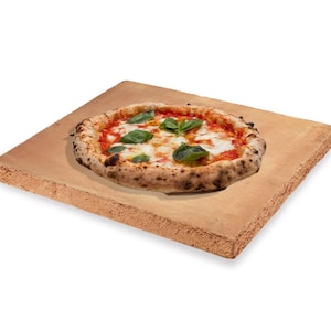 May include: A round pizza with tomato sauce, mozzarella cheese, and fresh basil leaves on a light brown rectangular pizza stone.