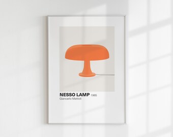 May include: Framed print featuring an orange Nesso Lamp design. The lamp has a rounded shade and a pedestal base. The print includes the text "NESSO LAMP 1965" and the designer's name, Giancarlo Mattioli. The artwork is displayed on a white wall.