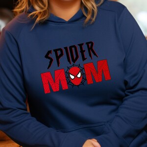 May include: Navy blue hoodie with a red and black graphic that says "Spider Mom" with a spider web design and a red spider head in the center.