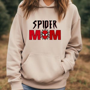 May include: A beige hoodie with a red and black graphic that says "SPIDER MOM" with a spider web and spider face in the middle.