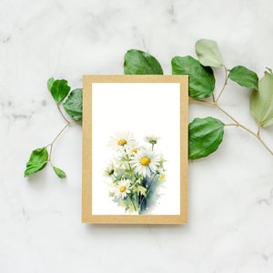 Puede incluir: Una pintura de acuarela de un ramo de margaritas blancas con centros amarillos sobre un fondo blanco. La pintura est&aacute; enmarcada en un marco de cartulina marr&oacute;n.