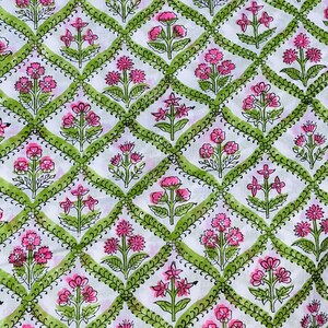 Puede incluir: Tela blanca con un patr&oacute;n repetido de flores rosas y bordes verdes en forma de diamante. El dise&ntilde;o floral incluye varias formas de flores, creando un patr&oacute;n textil visualmente atractivo. Adecuado para proyectos de costura y artesan&iacute;a.