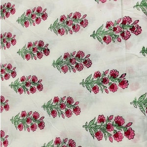 Puede incluir: Tela blanca con un patr&oacute;n repetido de flores rosas y hojas verdes. El dise&ntilde;o floral est&aacute; espaciado uniformemente, creando una est&eacute;tica delicada. La tela parece ligera y adecuada para diversos proyectos.