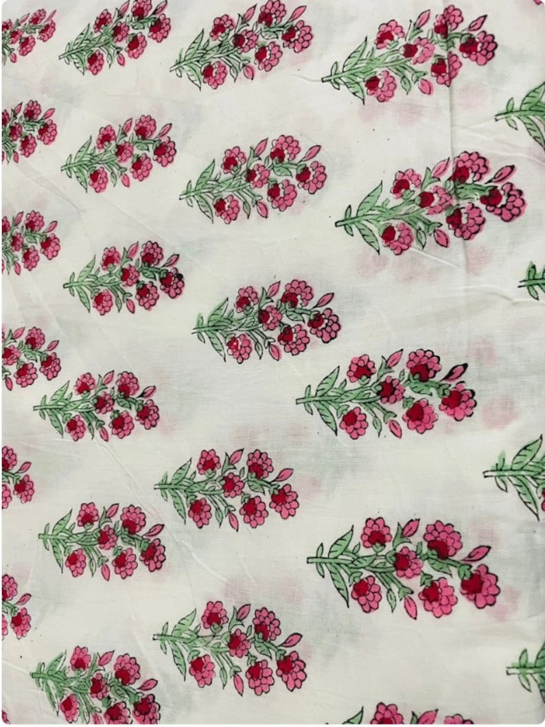 Puede incluir: Tela blanca con un patr&oacute;n repetido de flores rosas y hojas verdes. El dise&ntilde;o floral est&aacute; espaciado uniformemente, creando una est&eacute;tica delicada. La tela parece ligera y adecuada para diversos proyectos.