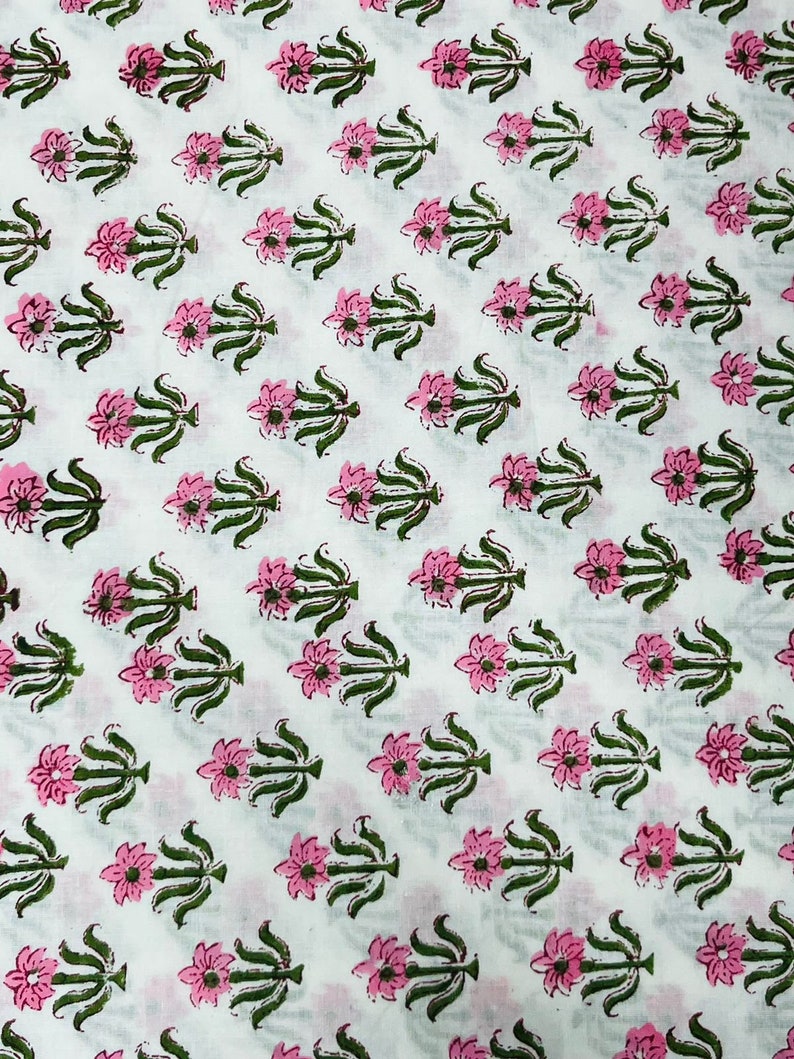 Puede incluir: Tela blanca con un patr&oacute;n repetido de flores rosas y hojas verdes. El dise&ntilde;o floral est&aacute; espaciado uniformemente, creando un patr&oacute;n consistente. La tela es probablemente de algod&oacute;n o un material similar, adecuado para varios proyectos textiles.