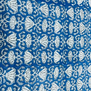Puede incluir: Primer plano de un patr&oacute;n floral azul y blanco. El dise&ntilde;o presenta motivos repetidos de flores y hojas blancas sobre un fondo azul vibrante. La tela tiene una apariencia texturizada, lo que sugiere una fibra natural.