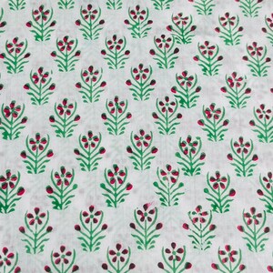May include: White fabric with a repeating pattern of green and pink stylized flowers.