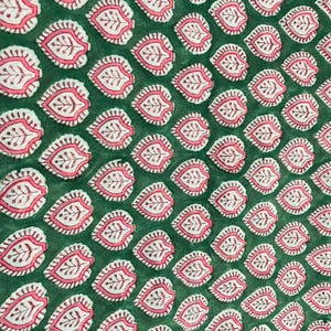 Op de afbeelding: Close-up van een groene stof met een herhaald patroon van roze en witte bladachtige ontwerpen. De bladeren hebben een gedetailleerd, aderachtig patroon aan de binnenkant. De stof heeft een licht getextureerd uiterlijk.