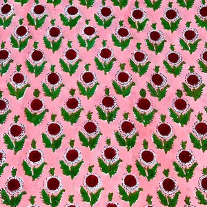May include: Pink fabric with a repeating pattern of white and red flowers with green leaves.