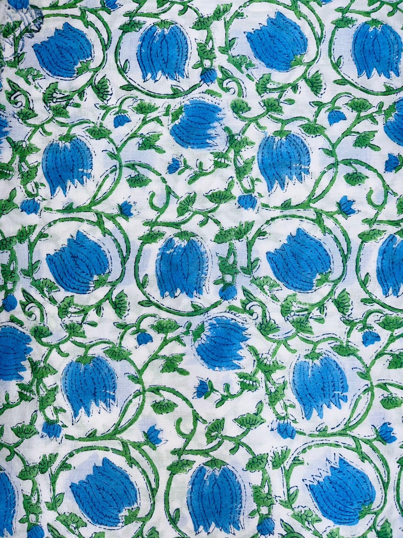 May include: White fabric with a repeating pattern of blue flowers and green leaves.