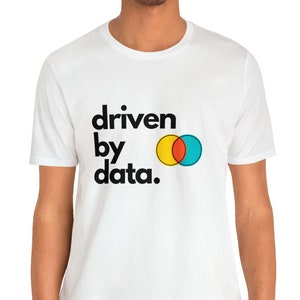 May include: White t-shirt with black text that reads "driven by data." The text is accompanied by a graphic of two overlapping circles, one yellow and one blue, with a red circle in the overlapping area.
