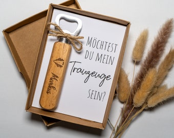 May include: A wooden bottle opener with the name "Markus" engraved on it, in a brown box with a white card that reads "Möchtest du mein Trauzeuge sein?" (Would you like to be my best man?).