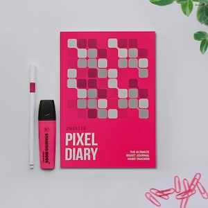 May include: A magenta Pixel Diary bullet journal with a pixelated pattern, a white pen, and a pink highlighter. The journal features the text "Pixel Diary" and "The Ultimate Bullet Journal Habit Tracker". Pink paperclips are also present.
