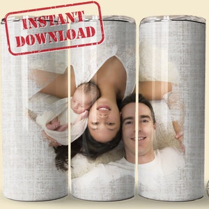 May include: A sublimation design for a 20 oz tumbler featuring a family of three, a mother, father, and a baby, lying on a white blanket. The design is perfect for a new parent gift.