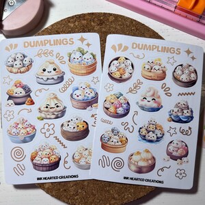 Könnte beinhalten: Zwei Blätter mit Aufklebern, die niedliche Cartoon-Knödel in verschiedenen Posen und Designs zeigen. Die Aufkleber sind weiß mit goldenen Akzenten und der Text "Dumplings" ist auf jedem Blatt gedruckt. Der Text "Ink Hearted Creations" ist unten auf jedem Blatt gedruckt.