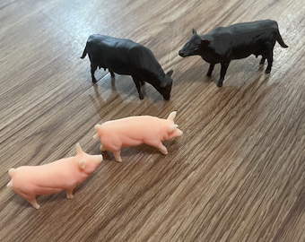Two Brown Angus Cows And Two Pigs.