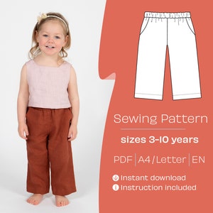 Può includere: Un cartamodello per pantaloni da bambino, taglie 3-10 anni. Il cartamodello è disponibile come download PDF in formato A4 o Letter, e include le istruzioni. L'immagine mostra una bambina che indossa i pantaloni di colore ruggine.