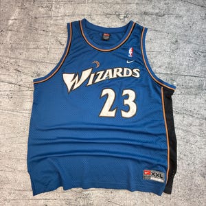 K&ouml;nnte beinhalten: Blaues Wizards-Basketballtrikot mit der Nummer 23 in Wei&szlig;. Das Trikot hat das Wizards-Logo auf der Vorderseite und ein Nike-Logo. Das Trikot ist in der Gr&ouml;&szlig;e XXL.