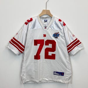 Op de afbeelding: Wit mesh voetbalshirt met rode accenten, waaronder strepen op de mouwen en het nummer 72 op de voorkant. Het shirt heeft het NFL-logo en een Super Bowl-patch.