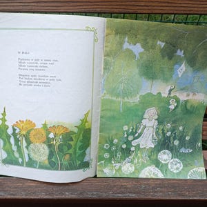 May include: An open book with a poem about dandelions in a field. The right page has an illustration of a girl in a white dress standing in a field of dandelions.