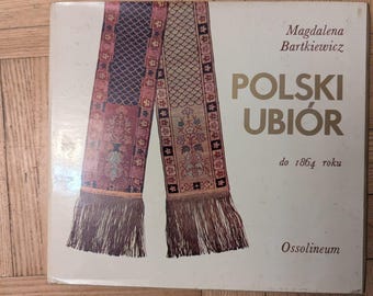 May include: A book cover featuring a detailed illustration of a traditional Polish textile design in shades of red, blue, and gold. The title "POLSKI UBIÓR" is prominently displayed, with the author's name and publisher's logo also visible.