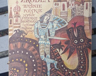 May include: Vintage Polish fairy tale book titled "U Złotego Źródła" with a knight illustration. The cover features a knight with a sword, a shield, and a dragon. The book's title and author's name are printed in Polish.