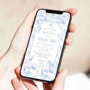 Op de afbeelding: Een smartphone toont een blauw-witte doopinformatie. Het ontwerp toont een safariscène met giraffen, olifanten en luchtballonnen. De uitnodiging bevat de naam "Charlie Luke", datum, tijd en locatiegegevens.