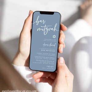May include: A smartphone displays a Bar Mitzvah invitation on a blue background. The invitation includes the text "bar mitzvah", the name "Oliver David", and event details. The phone is held by a person.