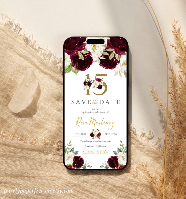 May include: A save the date card for a quincea&ntilde;era celebration. The card features a floral design with burgundy and white roses, and gold lettering. The text reads "Save the Date for the Quincea&ntilde;era celebration of Rosa Martinez, Saturday, August 25, Two thousand and twenty xxxx, Anytown, California, Invitation to follow."