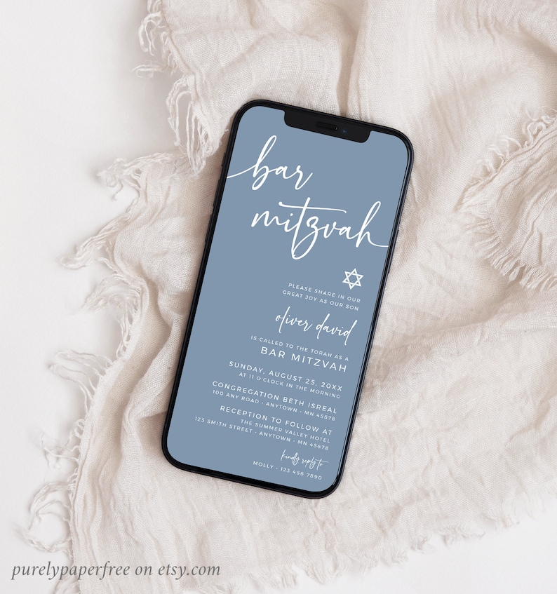 May include: A smartphone displays a Bar Mitzvah invitation. The invitation features elegant white script on a dusty blue background, with a Star of David symbol. The text includes the name Oliver David, date, time, and location details.