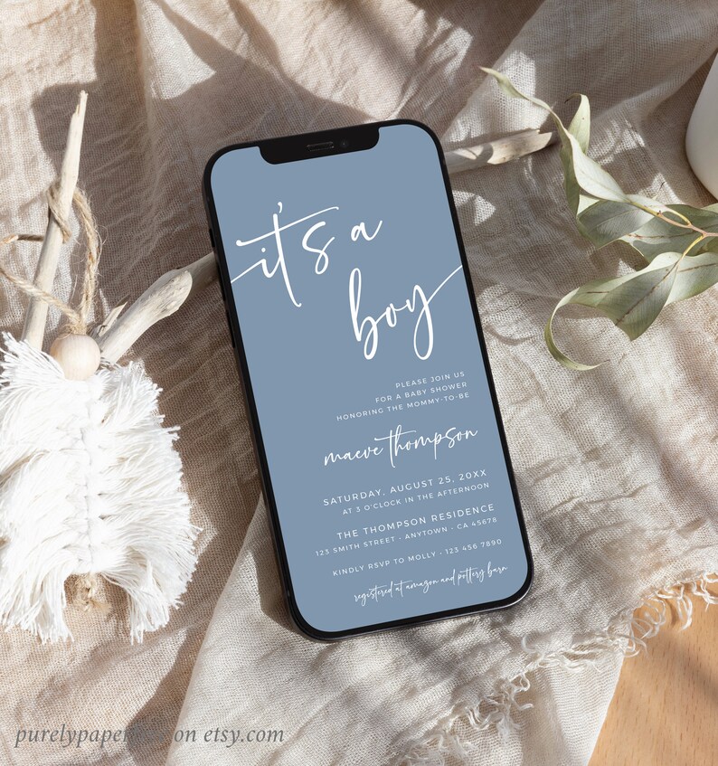 May include: A blue and white baby shower invitation on a smartphone screen. The invitation reads "It's a boy" in white script. The invitation includes the name "maeve thompson" and details for the baby shower.