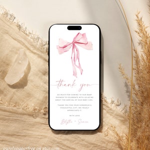 Puede incluir: Un lazo rosa acuarela con una tarjeta de agradecimiento para un baby shower. La tarjeta dice "Gracias" y "Muchas gracias por venir a nuestro baby shower para celebrar con nosotros la llegada de nuestra ni&ntilde;a. Gracias por su generoso y atento regalo, lo apreciamos mucho. Con amor, Blythe & Simon."