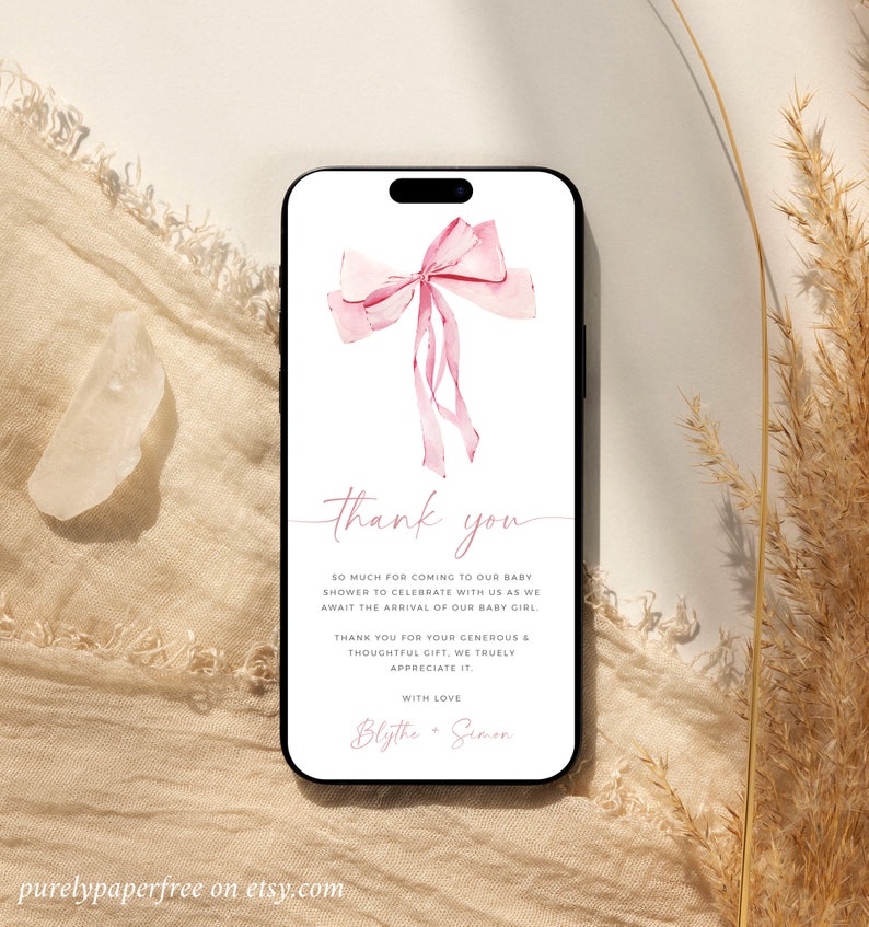 Puede incluir: Un lazo rosa acuarela con una tarjeta de agradecimiento para un baby shower. La tarjeta dice "Gracias" y "Muchas gracias por venir a nuestro baby shower para celebrar con nosotros la llegada de nuestra ni&ntilde;a. Gracias por su generoso y atento regalo, lo apreciamos mucho. Con amor, Blythe & Simon."