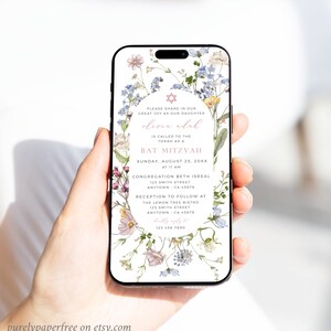 May include: A floral phone screen mockup with a Bat Mitzvah invitation for Olivia Adah. The invitation includes the date, time, and location of the event. The text reads: "Please share in our great joy as our daughter Olivia Adah is called to the Torah as a Bat Mitzvah. Sunday, August 25, 20XX at 11 AM. Congregation Beth Isreal 123 Smith Street Anytown, CA 45678. Reception to follow at The Lemon Tree Bistro 123 Smith Street Anytown, CA 45678. RSVP to 123 456 7890."