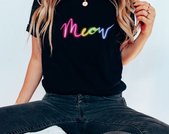 Könnte beinhalten: Ein schwarzes T-Shirt mit einem regenbogenfarbenen Neon-„Meow“-Motiv.