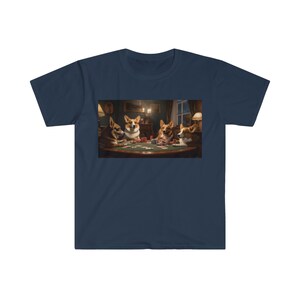May include: Navy blue t-shirt featuring a humorous image of four corgi dogs playing poker around a table. The dogs are depicted in a room with a warm, inviting atmosphere, complete with a poker table, cards, and chips.