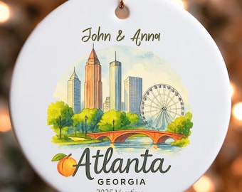 Puede incluir: Adorno navideño redondo de cerámica blanca con una ilustración del horizonte de Atlanta, un melocotón y el texto "Atlanta Georgia 2025 Vacations". El adorno está personalizado con los nombres "John & Anna".