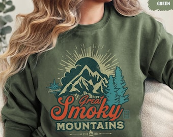 Könnte beinhalten: Ein grünes Sweatshirt mit einer Vintage-Grafik von Bergen und Bäumen. Die Grafik zeigt "Great Smoky Mountains" mit einem Kompass und dem Text "Est. 1970 Est. 1975".
