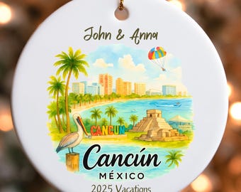 May include: Circular white ceramic Christmas ornament with a gold hanging loop. The ornament displays a vibrant illustration of Cancún, Mexico, with palm trees, buildings, and a pelican. Text includes "John & Anna" and "Cancún México 2025 Vacations."