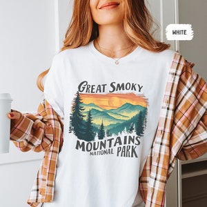 May include: White t-shirt with a vintage-style graphic of a mountain range with the text "Great Smoky Mountains National Park".