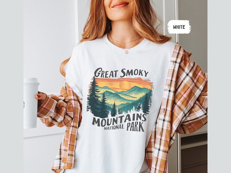 May include: White t-shirt with a vintage-style graphic of a mountain range with the text "Great Smoky Mountains National Park".