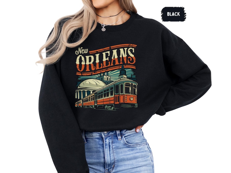 May include: Black sweatshirt with a vintage-style graphic of a streetcar in New Orleans. The text "New Orleans" is in a bold, retro font.